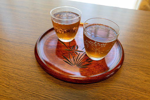 Two glasses of cold tea on Japanese wooden tray