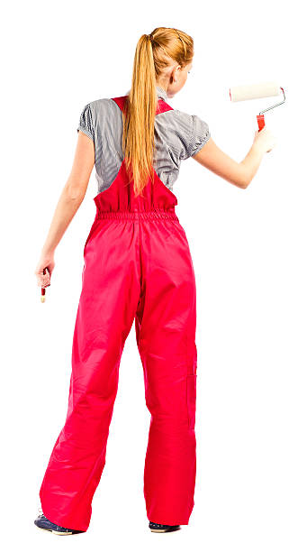 istock Young woman in red overalls with painting tools 157129336