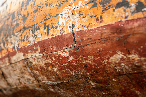 Tire fenders on the starboard side of a rusty Thai ferry with golden sunrise light and reflections in the water
