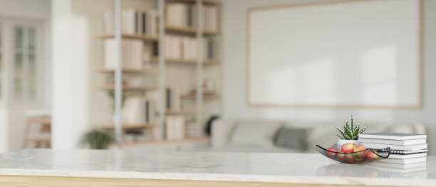istock Empty space on a tabletop with a blurred modern white living room as a background. 1571297632