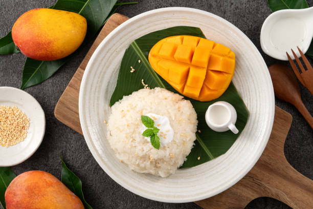 istock Delicious Thai mango sticky rice with cut fresh mango fruit in a plate. 1571303024