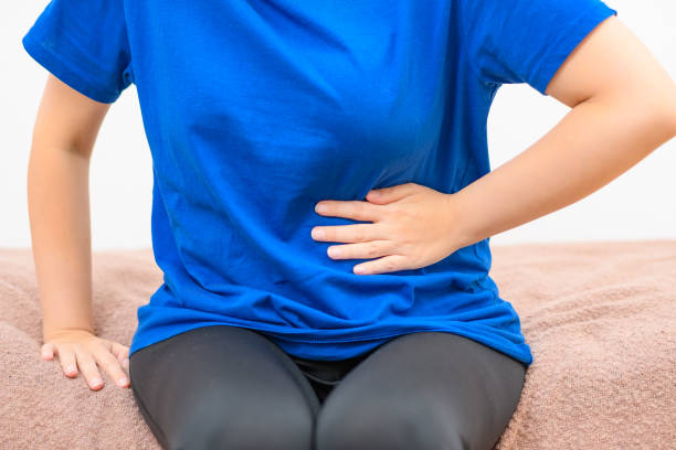 istock Patient sitting on the bed holding her stomach 1571328309