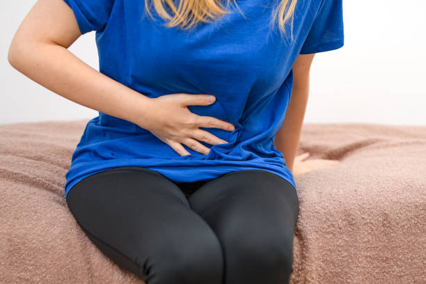 istock Young woman holds her stomach, female problems, menstrual pains 1571328880
