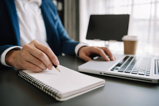 istock businesswoman hand working with new modern computer and writing on the notepad strategy diagram as concept morning light 1571341902