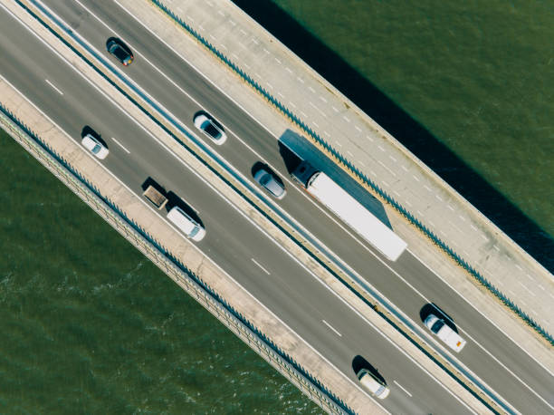 istock Bridge over a lake with traffic on the highway seen from above 1571387611