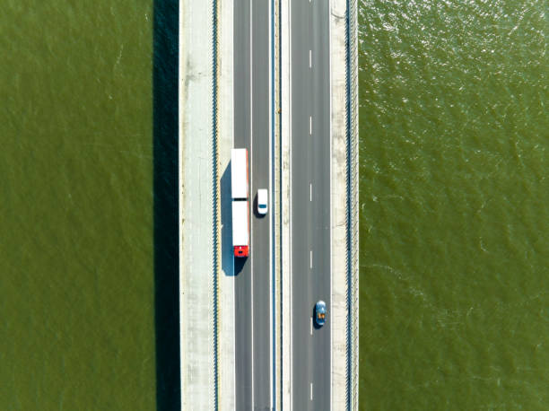 istock Bridge over a lake with traffic on the highway seen from above 1571388169