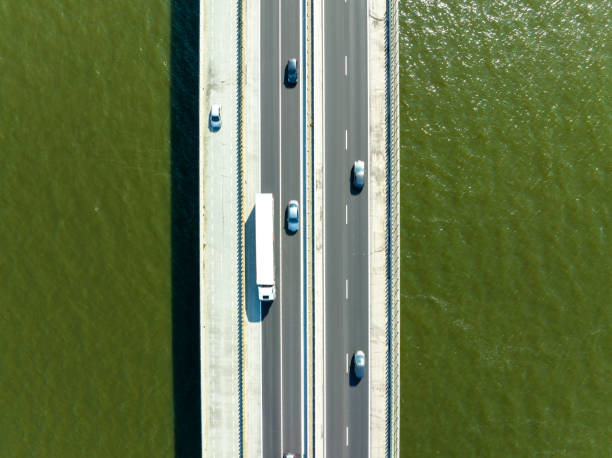 istock Bridge over a lake with traffic on the highway seen from above 1571388703