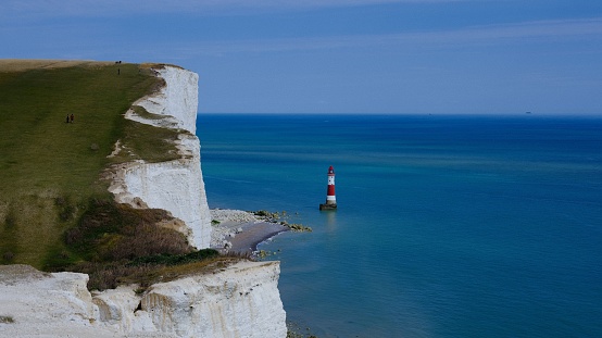 A scenic view of a lighthouse at Seven sisters cliffs in England, UK on a sunny day