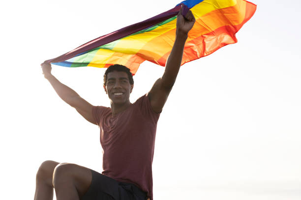 Free Stock Photo of Young man at the beach, holding rainbow pride flag ...