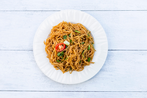Stir-fried Thai rice noodle on wooden table background, Pad khanom jeen in Thai name, simple asian fried noodle