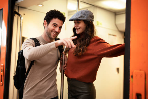 istock Young woman and man waiting to board a train. 1571417006