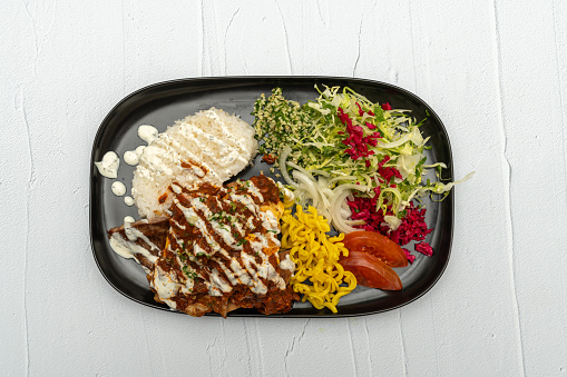 table top view of chicken kebab with rice and salad