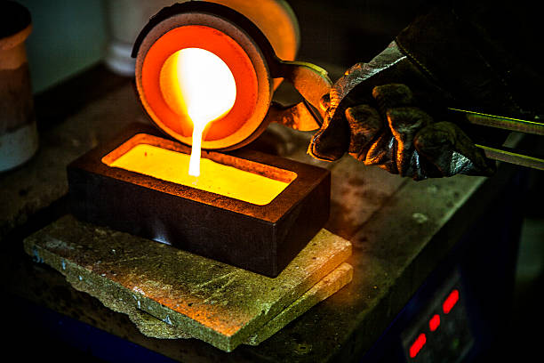 Fine gold casting pour a fine gold bar at over 2000 degrees. melting stock pictures, royalty-free photos & images