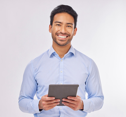 Portrait, smile and business man with tablet in studio isolated on a white background. Ceo face, professional boss and happy Asian male entrepreneur from Singapore from with touchscreen technology.
