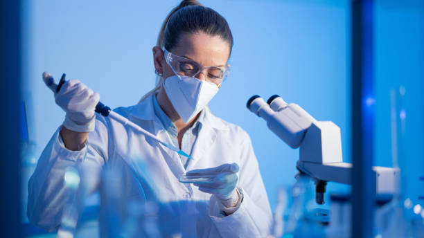 istock Female research scientist is analysing a sample on her microscope in a microbiology lab 1571480205