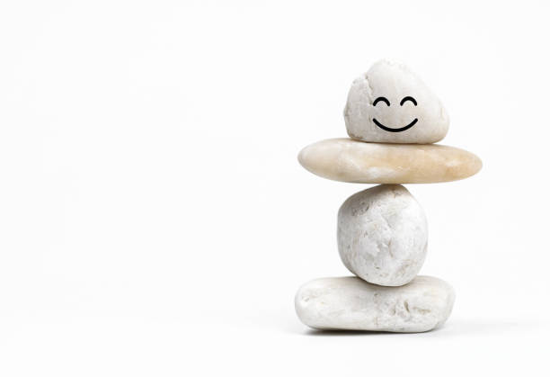 Positive Mind and Harmony, Enjoying Life Concept, Hand Setting Natural Pebble Stone with Smiling Face Cartoon to Balance. Balancing Body, Mind, Soul and Spirit. Mental Health Practice.