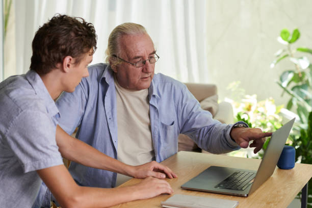istock Helping Grandfather with Installing Applications 1571488387
