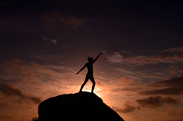 istock Goddess on a Rock at Sunrise Silhouetted by Sky 1571491194