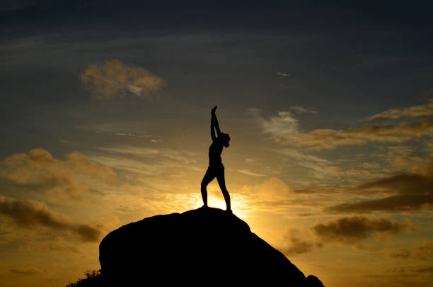 istock Silhouette Reaching for the Sky at Sunrise 1571492965