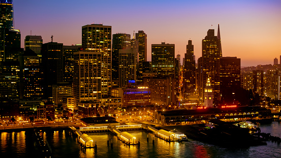 Aerial view of modern skyscraper buildings and harbour in city during dusk, San Francisco, California, USA.