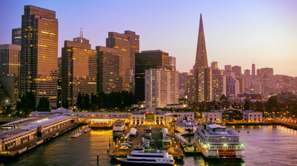 View of commercial dock in city Aerial view of commercial dock against city during dusk, San Francisco, California, USA. transamerica pyramid san francisco stock pictures, royalty-free photos & images