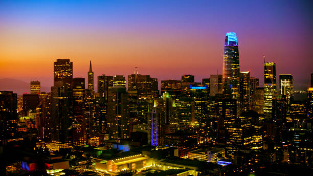 Aerial view of modern downtown city against orange sky during dusk, San Francisco, California, USA.