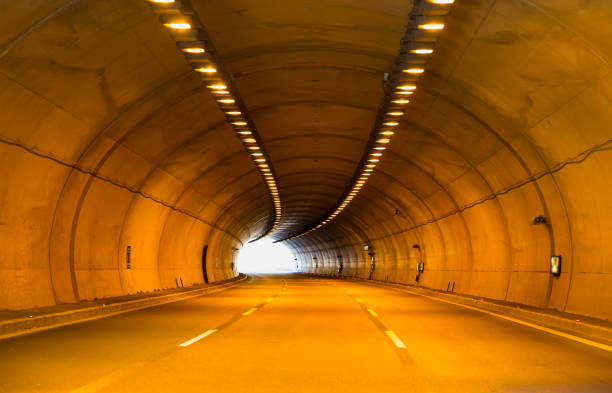 istock Highway road tunnel with car light 1571500414