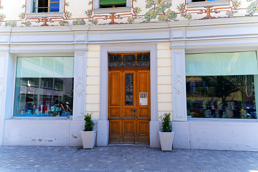 Facades of historic house with wooden door at the old town of Swiss City of Zug on a sunny spring day. Photo taken May 22nd, 2023, Zug, Switzerland.