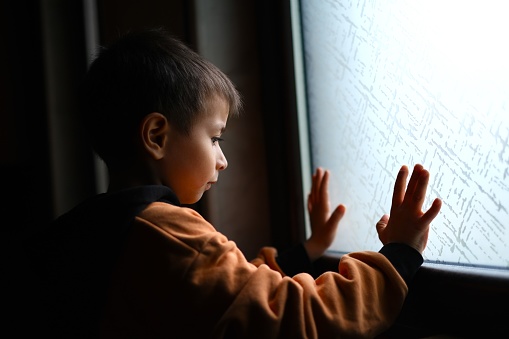 Window Hands.  Boy who misses going out puts his hands towards the window and signals outside