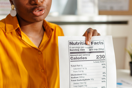 A female nutritionist explaining to her client nutrition facts on product label.