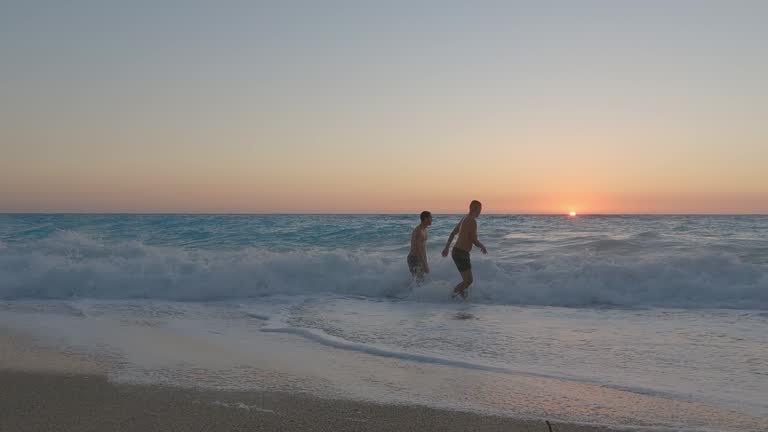 Young friends enjoying the sunset on Kathisma Beach in Lefkada, Greece. Slow motion