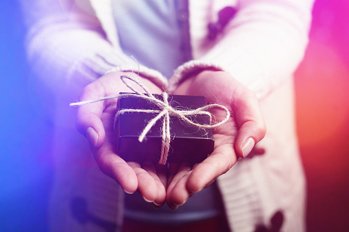 Woman is showing the gift package in her hands