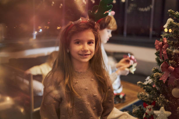 istock Happy girl decorating Christmas Tree 1571609638