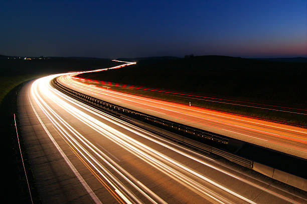 faróis e lanternas traseiras de carros na estrada na noite, exposição longa - car highway speed traffic - fotografias e filmes do acervo