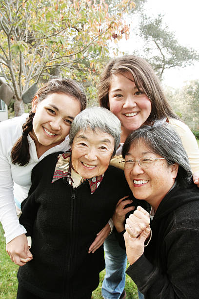 Happy extended family enjoying in conversation on sofa in the living room. Focus is on mature woman.