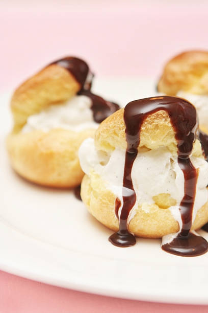 istock Close-up of profiteroles pastries on white plate 157163680