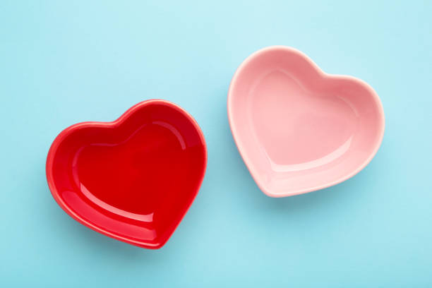 istock Red and pink heart shaped bowls on blue background. 1571637414