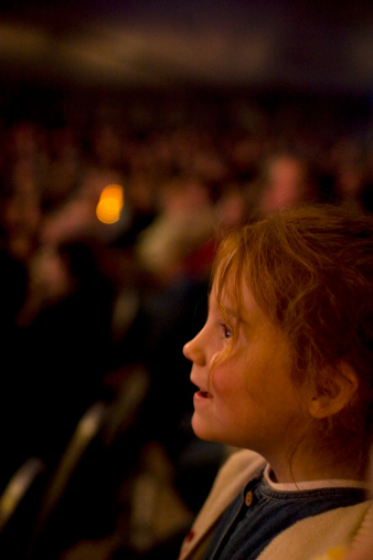 Young girl at the circus, amazed by all those wonderful tricks on stage.