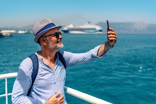 Mature tourist using a ferry and using the phone