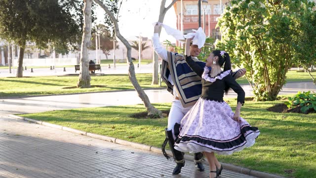 mixed group of four people dressed as huaso dancing cueca in the town square