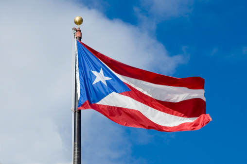 Close-up view of the Cuba national flag waving in the wind. The Republic of Cuba is an island state in Central America. Fabric textured background. Selective focus.