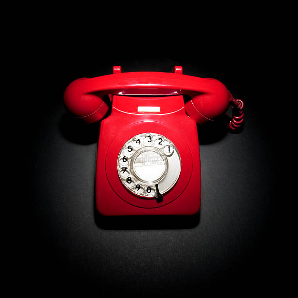 Red phone on black A retro red telephone in a spotlight on a black background red phone stock pictures, royalty-free photos & images