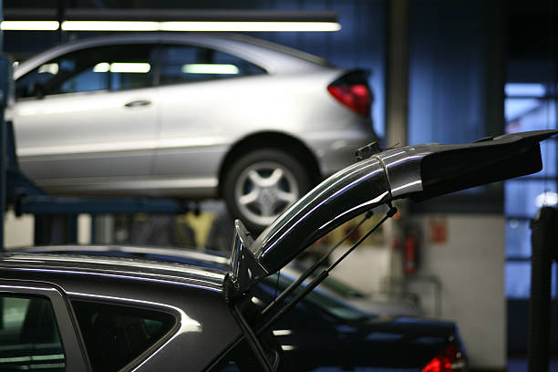The car broke down while traveling. A frustrated man near a broken car with an open hood far outside the city.  A young guy looks under the hood of a car.