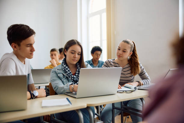 istock High school classmates cooperating while learning on laptop in the classroom. 1571674960