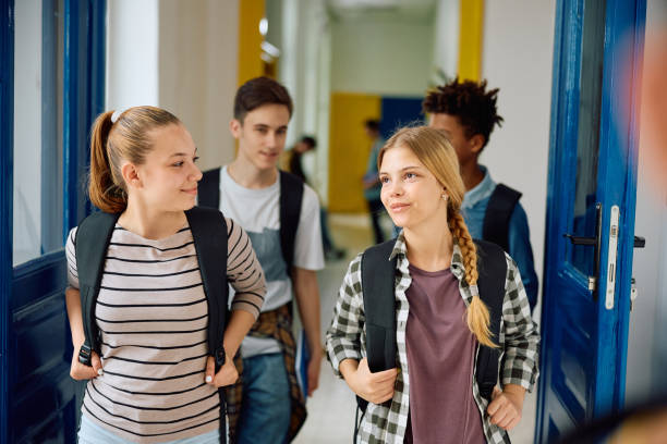 istock Group of high school students walking through hallway at school. 1571678054