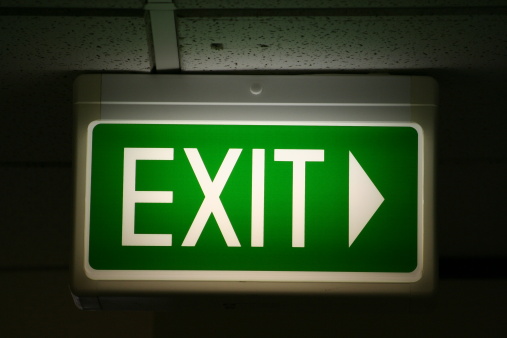 A green emergency exit sign found in an office.