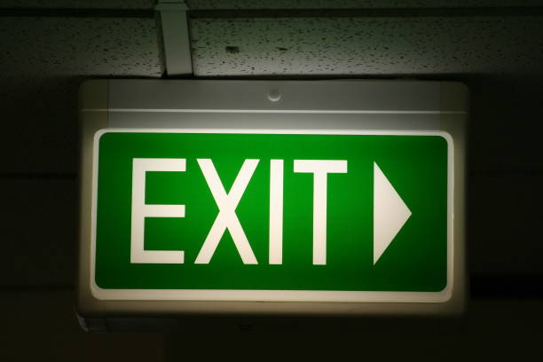 Flashing green emergency exit sign pointing to right stock photo