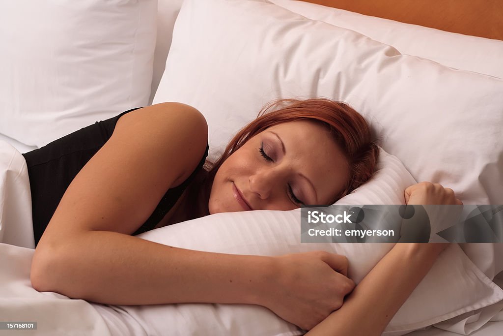 Sleepy Time Young woman sleeping comfortably in her bed. Sleeping Stock Photo