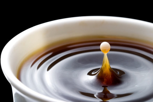 A drop of milk in a black coffee