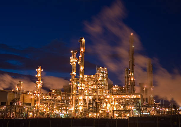 raffineria di petrolio illuminati di notte - petrochemical plant oil refinery factory outdoors foto e immagini stock